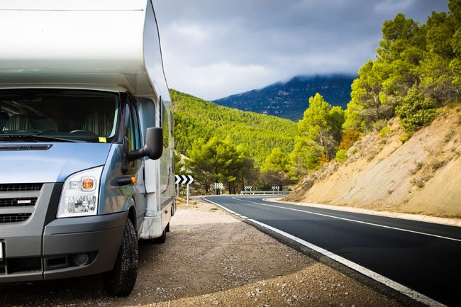 "White motorhome parked in a scenic countryside, representing flexible travel covered by Worthington Motorhome Insurance."