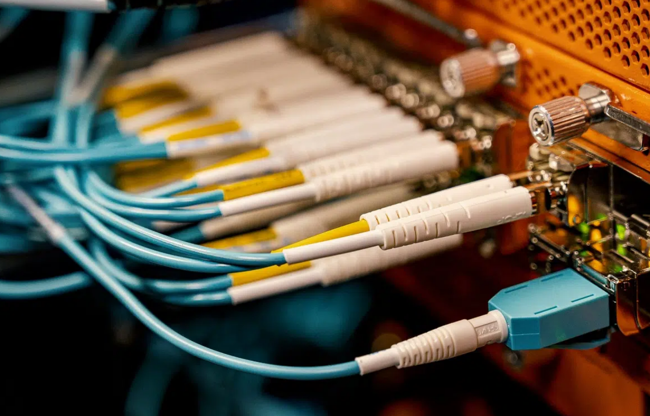 a technician installing cables in an office setting. The image represents general liability insurance coverage for cable installation businesses, highlighting the importance of risk protection during such operations. The scene is a well-lit workspace with the technician carefully handling tools, underscoring the necessity of insurance for unexpected incidents.